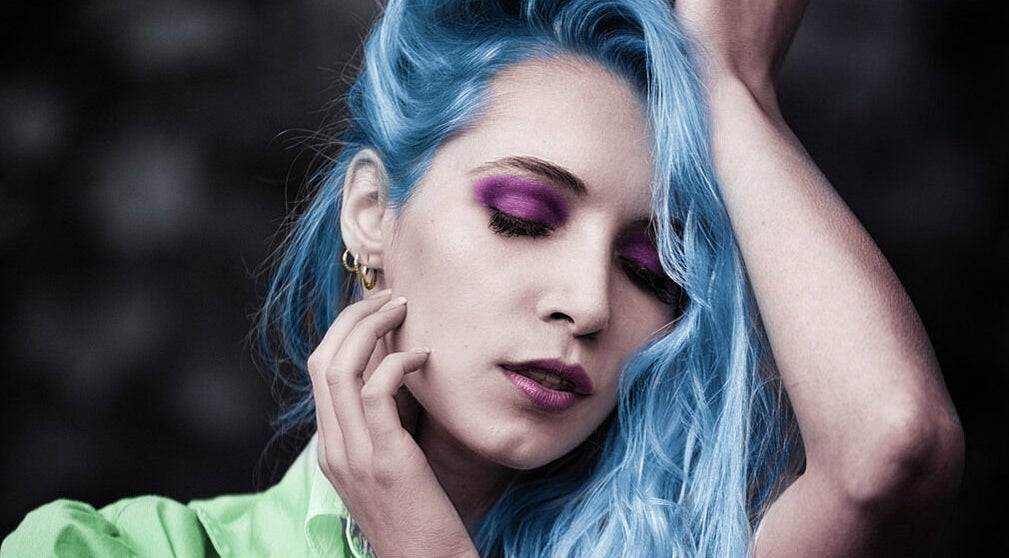 Model with blue hair and bold makeup at Salon 102 & Spa, West Greenwich, Rhode Island, US.