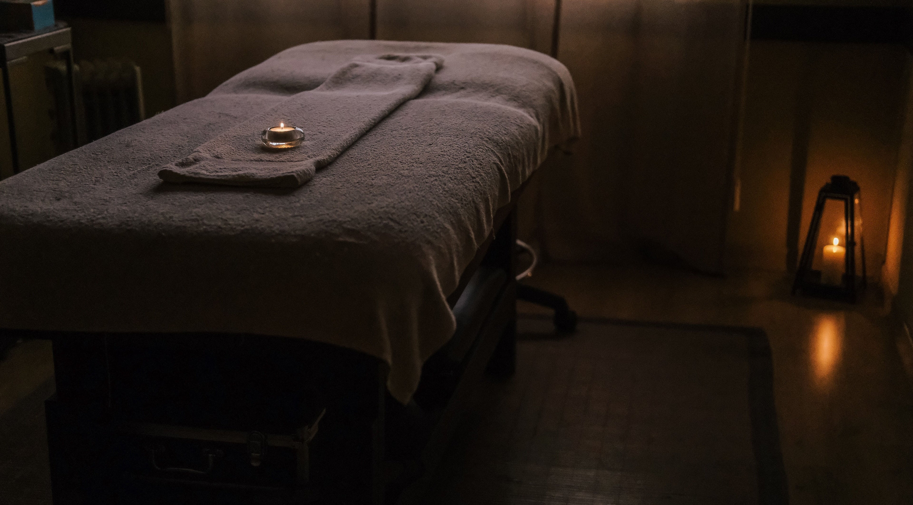 Sala de massagem no Zen Spa, Tomar, Santarém, PT, com luz suave e vela acesa.