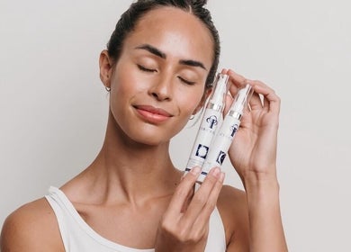 Woman holding skincare products at Ease Esthetics & Massage, Tulsa, Oklahoma, US, showcasing radiant skin.