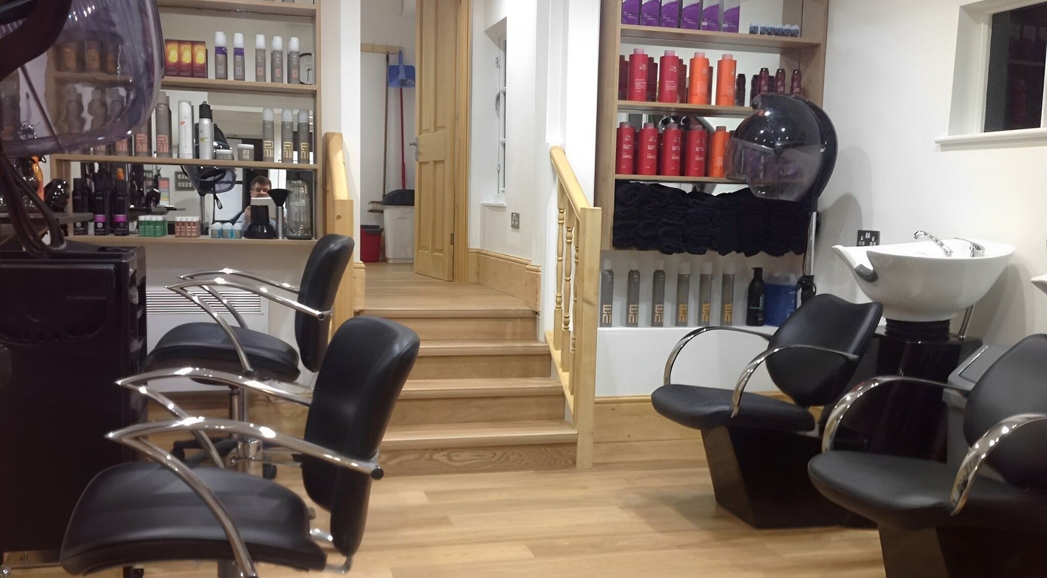 Modern interior of Forge Hair Salon in Rotherfield, England, GB with sleek chairs and product shelves.