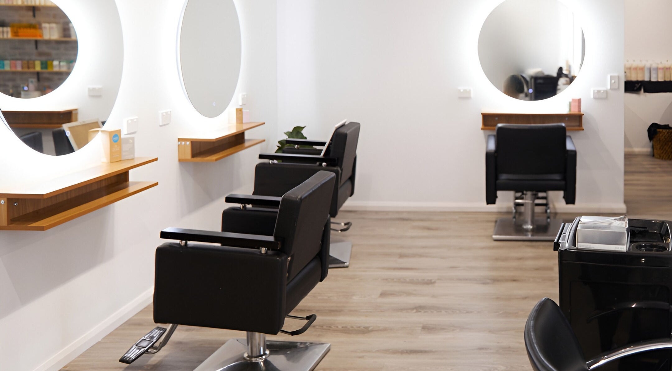 Modern salon chairs and mirrors at Harlow & Co, Coffs Harbour, New South Wales, AU, showcasing elegance.