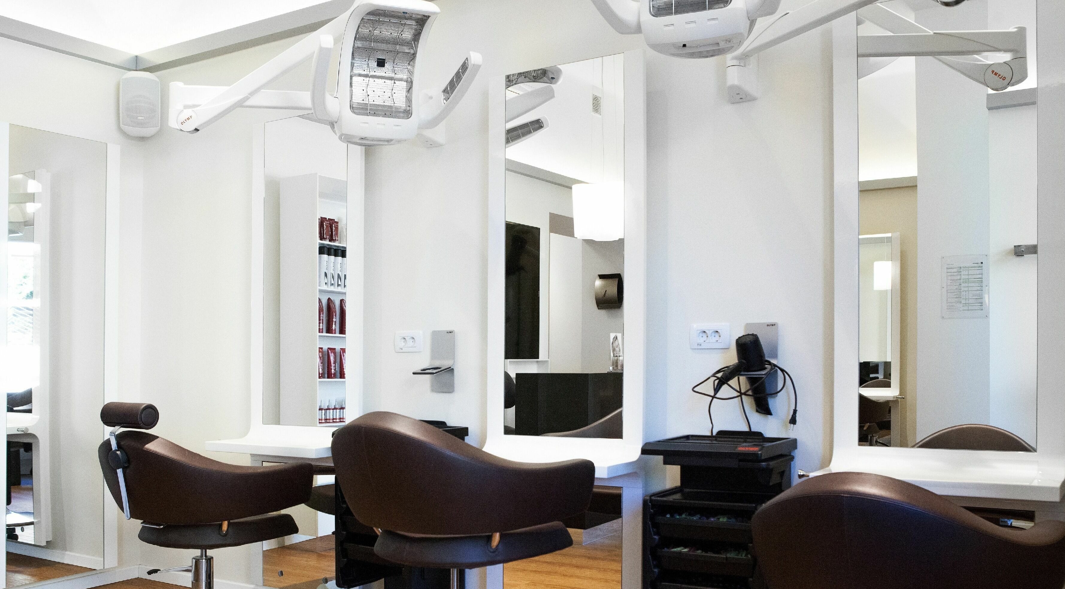 Notranjost salonske sobe Lassana Frizerski Salon - Celovška 49 v Ljubljani, Ljubljana, SI z moderno oblikovanimi stoli.