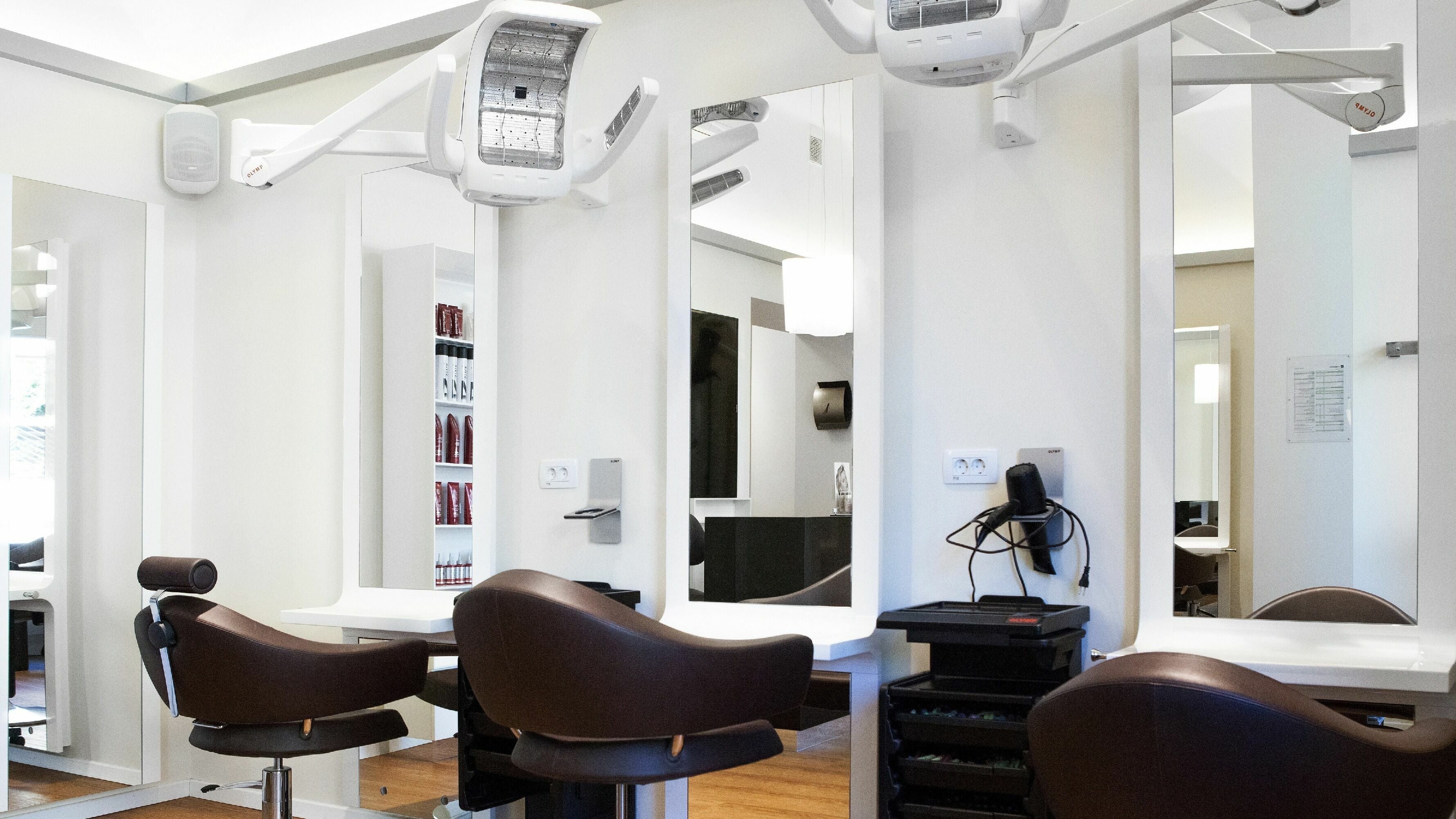 Notranjost salonske sobe Lassana Frizerski Salon - Celovška 49 v Ljubljani, Ljubljana, SI z moderno oblikovanimi stoli.