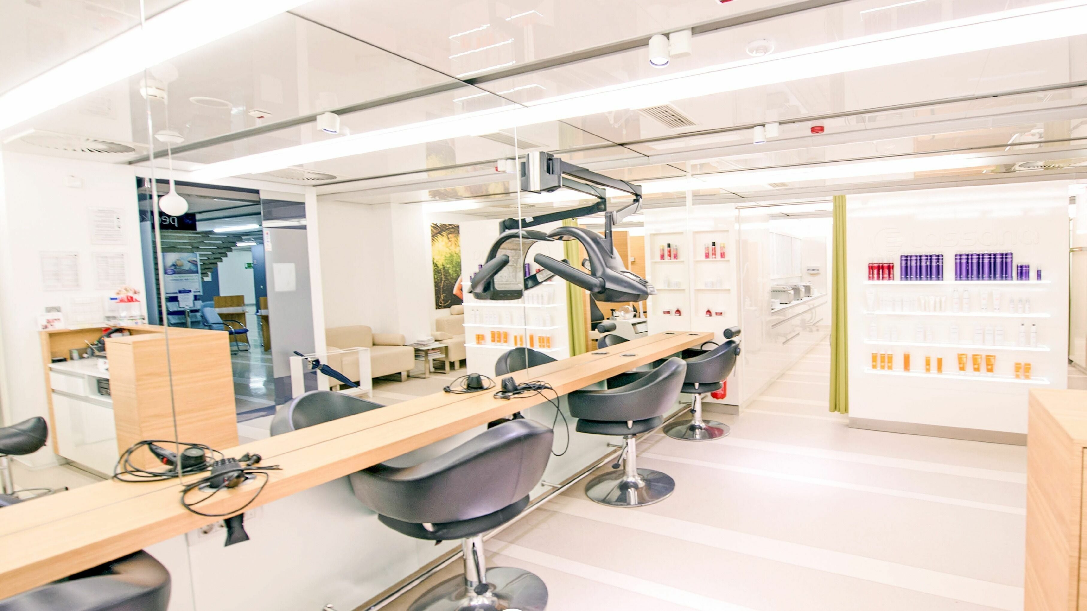 Notranjost Lassana Frizerski in Kozmetični Salon - Zaloška 7, Ljubljana, Ljubljana, SI z elegantnimi stoli in osvetlitvijo.