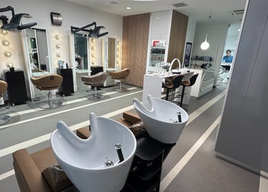 Notranjost salona Lassana Litijska 38 v Ljubljani, Ljubljana, SI z modernimi frizerskimi sedeži in umivalniki.