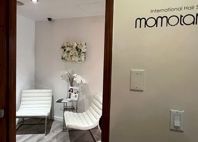 Entrance to Momotaro, a chic beauty salon in New York, US, showing elegant white chairs and decor.