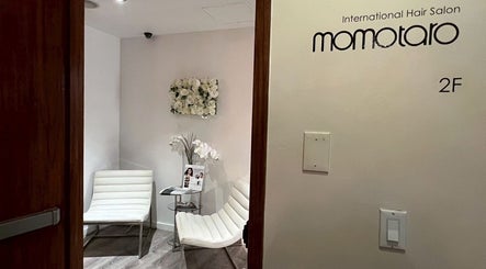 Entrance to Momotaro, a chic beauty salon in New York, US, showing elegant white chairs and decor.
