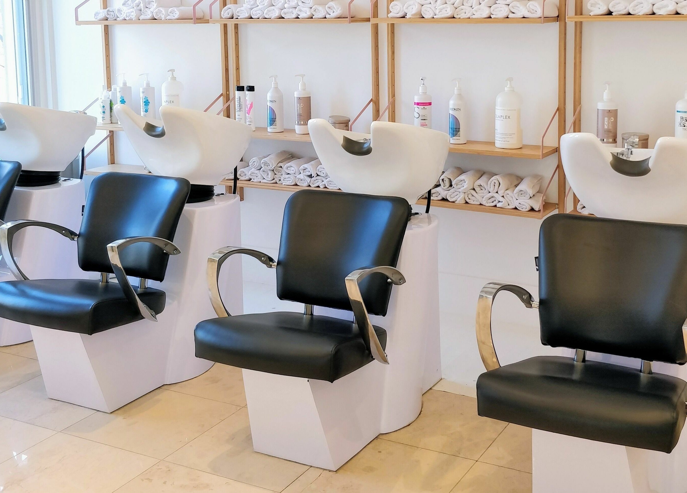 Nu Salon's sleek wash stations in Montréal, Québec, CA. Modern chairs with elegant fixtures and product shelves.