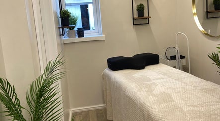 Calm treatment room at Elm Tree Beauty, Westfield, England, GB, featuring a massage table and serene decor.