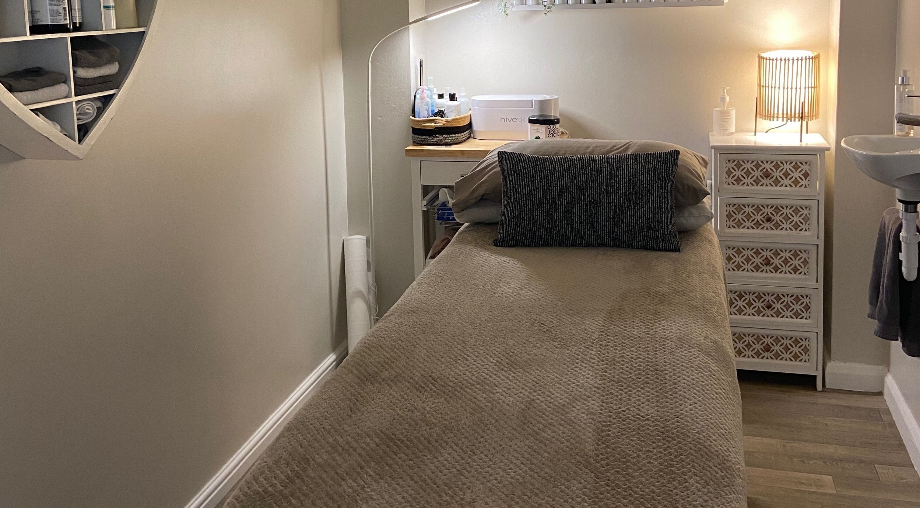 Cozy massage room at Elm Tree Beauty in Westfield, England, GB, featuring a treatment bed and soft lighting.