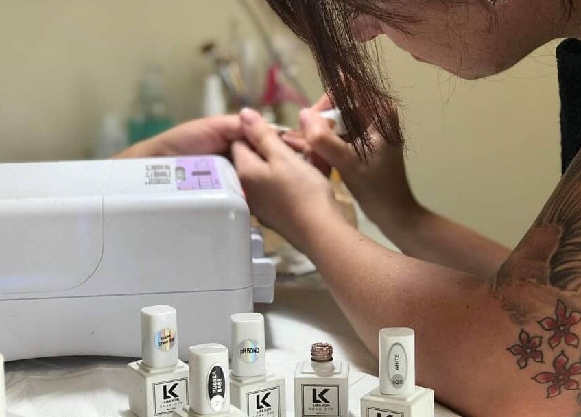 Nail artist applying polish at Tips 2 Toes Boutique, Wall Heath, England, GB.