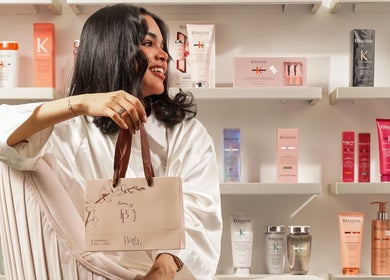 Woman at Posh N Polish Nail Spa & Salon in Al Hofuf holding beauty products with Kerastase display backdrop.