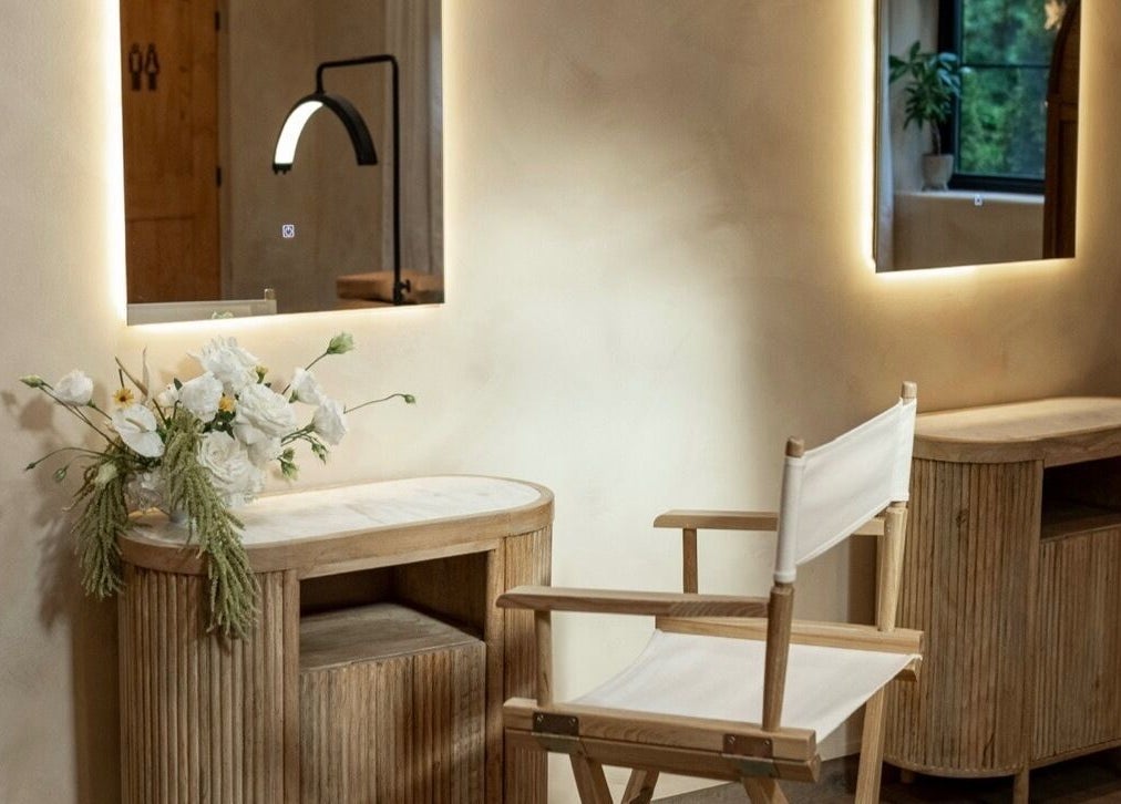 Elegant makeup station at Mood Beauty Co., Brant, Ontario, CA, featuring a chair and mirror with floral accents.