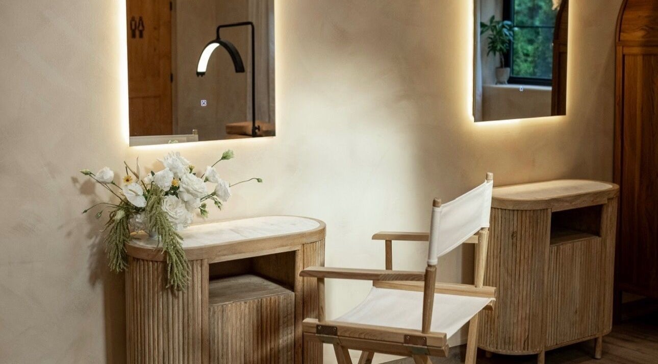 Elegant makeup station at Mood Beauty Co., Brant, Ontario, CA, featuring a chair and mirror with floral accents.