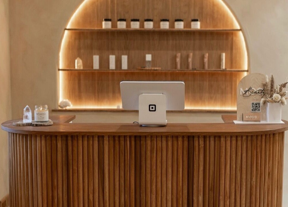 Elegant reception desk at Mood Beauty Co. in Brant, Ontario, CA showcasing modern design and warm lighting.