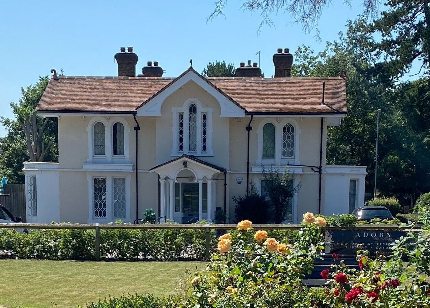 Exterior of Trends Brow Bar in Hoddesdon, England, showcasing a picturesque setting surrounded by flowers.