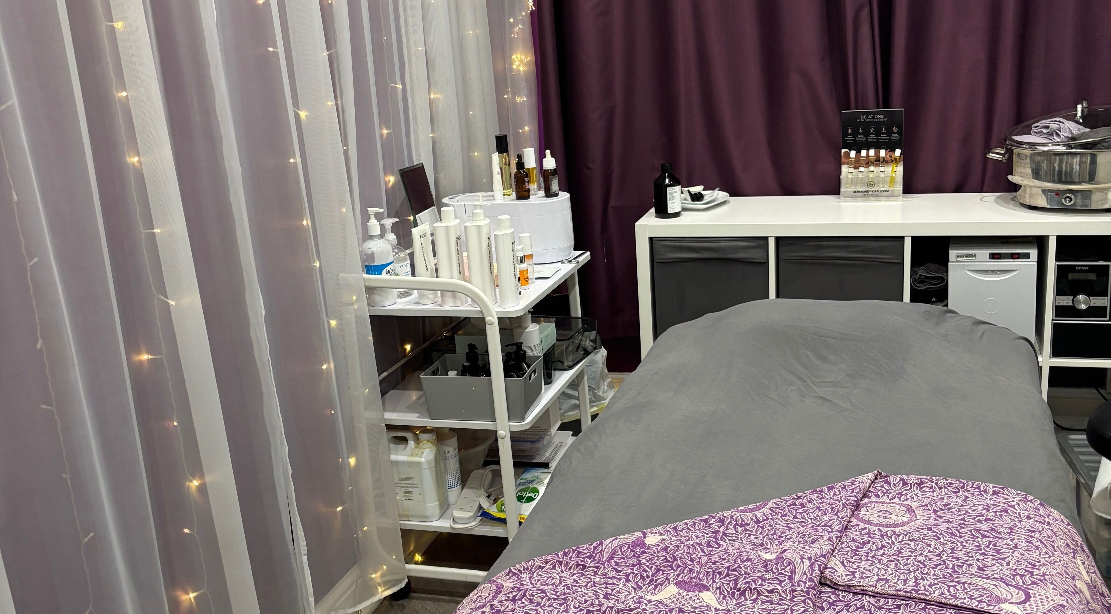 Tranquil spa room at Rainbows and Dreams Beauty, Watford, England, GB with massage bed and beauty products.
