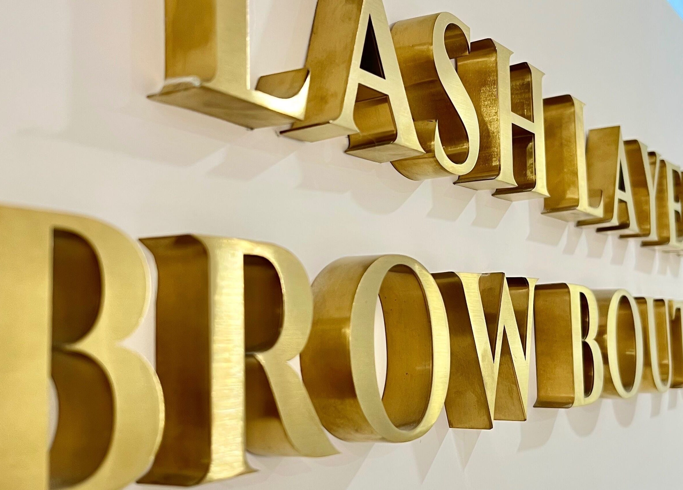 Elegant signage of Lash Layer and Brow Boutique in Pickering, Ontario, CA with golden letters.