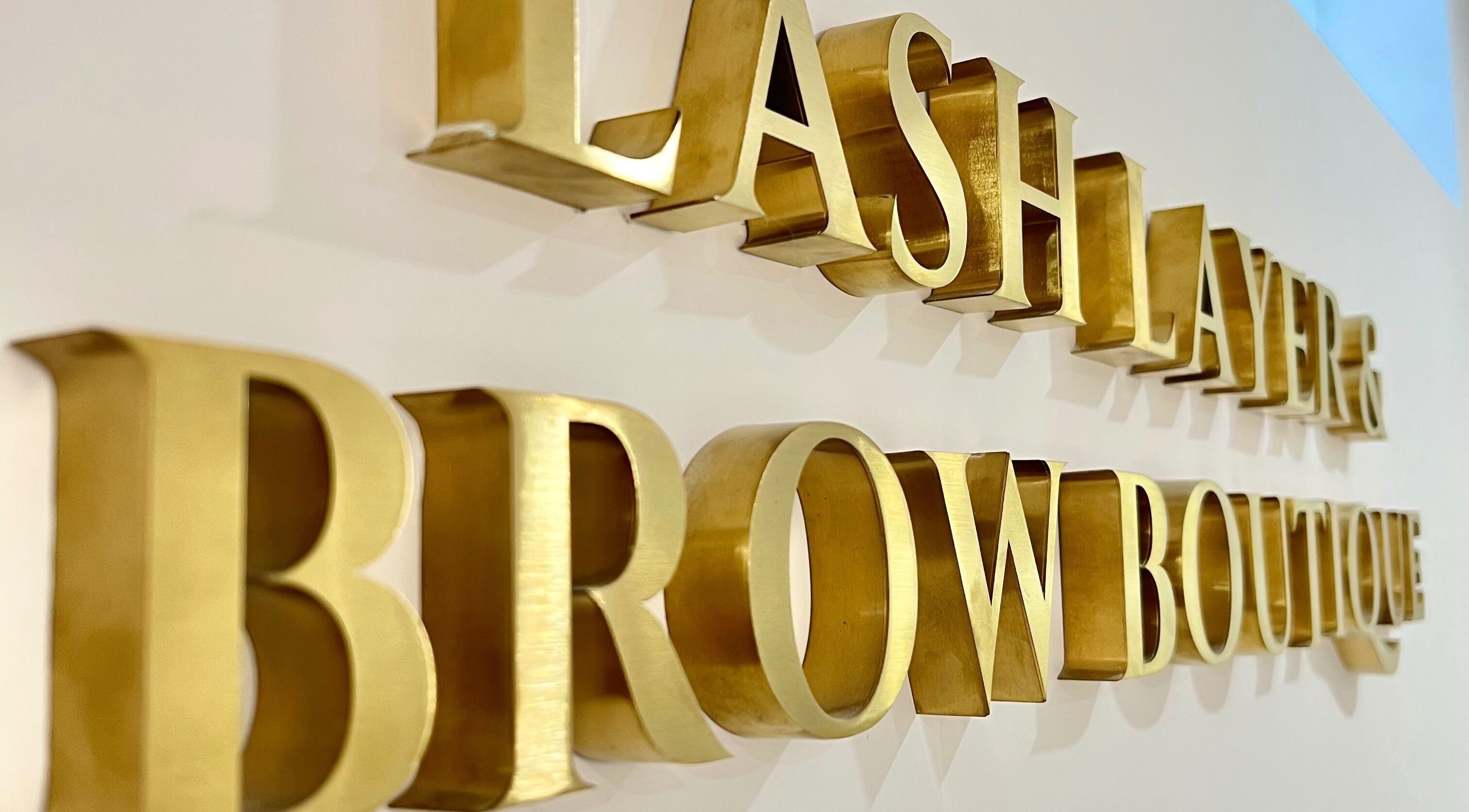 Elegant signage of Lash Layer and Brow Boutique in Pickering, Ontario, CA with golden letters.