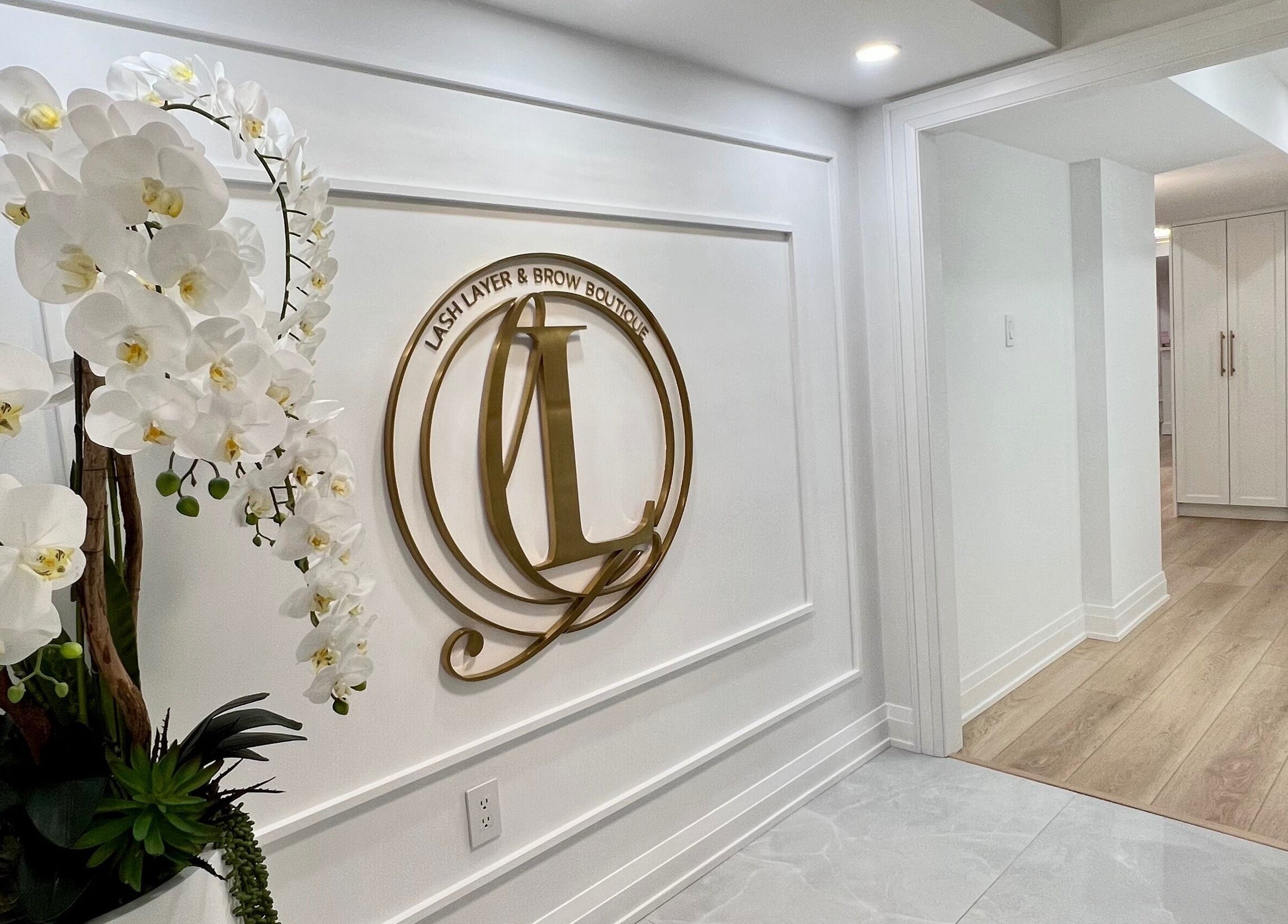 Entrance of Lash Layer and Brow Boutique, adorned with elegant orchids in Pickering, Ontario, CA.