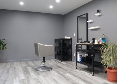 Modern salon interior at The Spot in Montréal, Québec, CA with a stylish chair and potted plants.