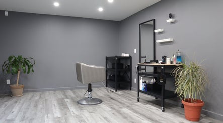Modern salon interior at The Spot in Montréal, Québec, CA with a stylish chair and potted plants.