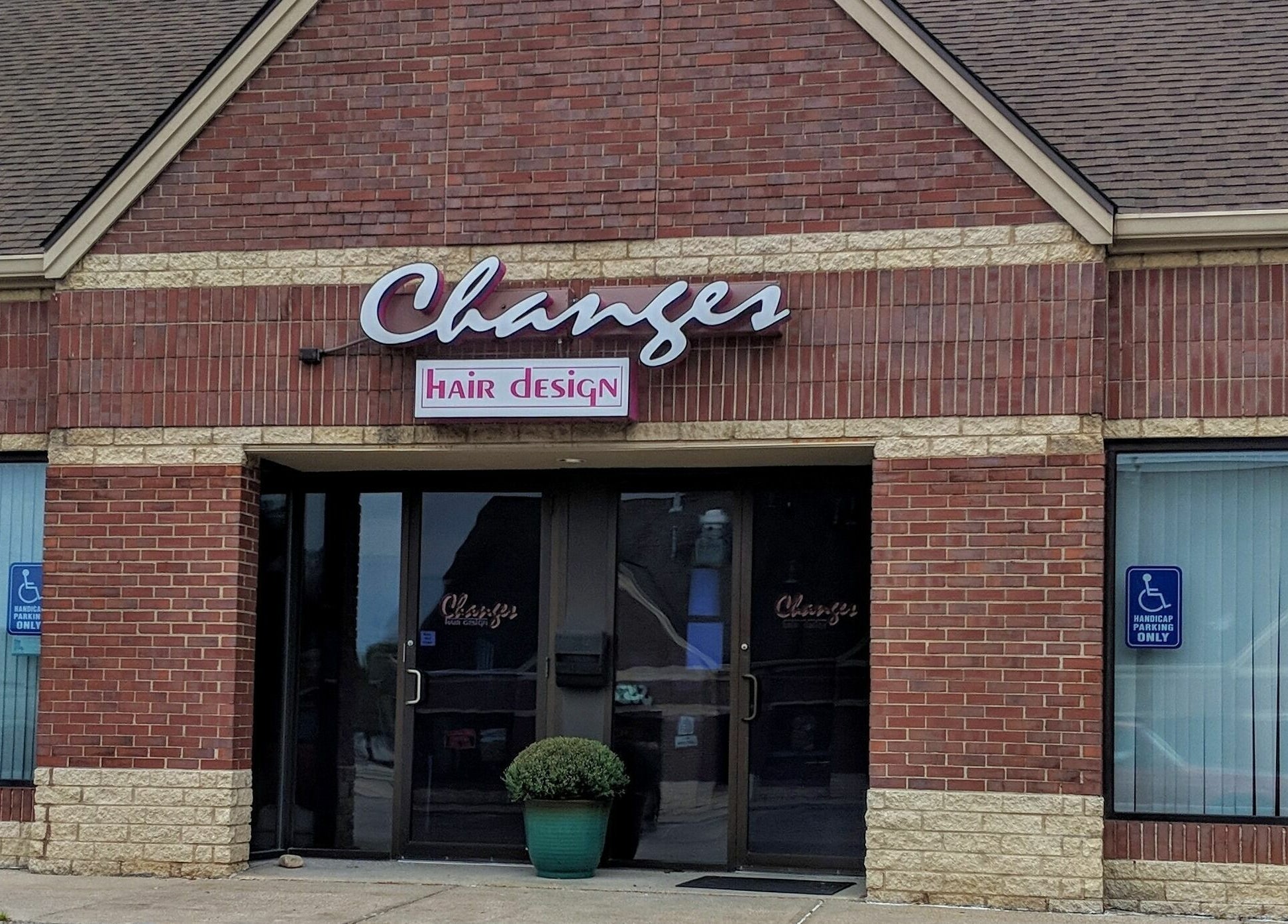 Front view of Changes Hair Design, Meridian Charter Township, Michigan. Red brick exterior with inviting entrance.
