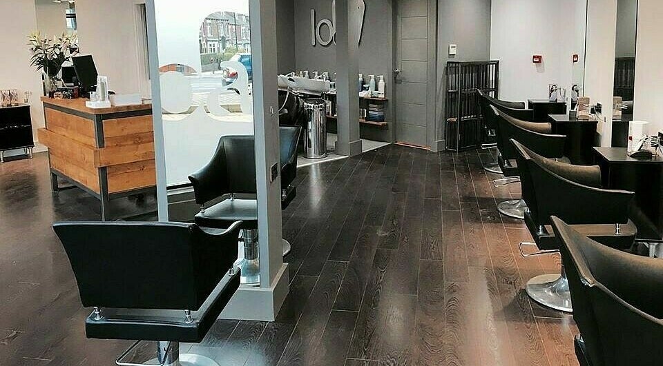 Modern interior of Loaf Hair salon in Sheffield, England, GB with sleek black chairs and elegant wooden accents.