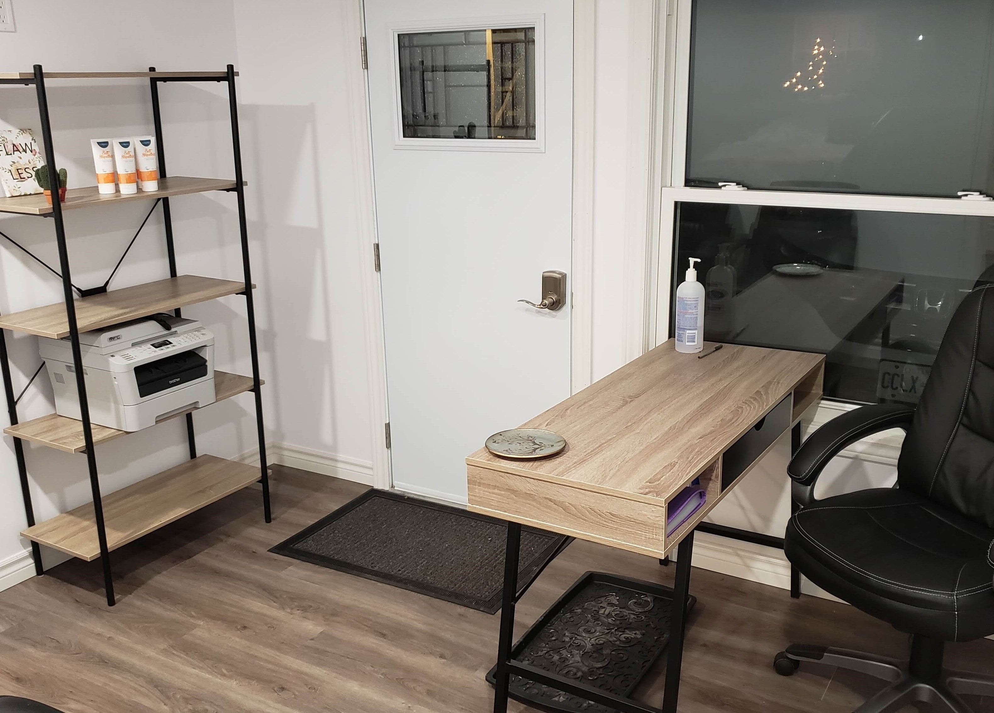 Modern office space at The Sugary, Peterborough, Ontario, CA with desk, chair, and shelving unit.