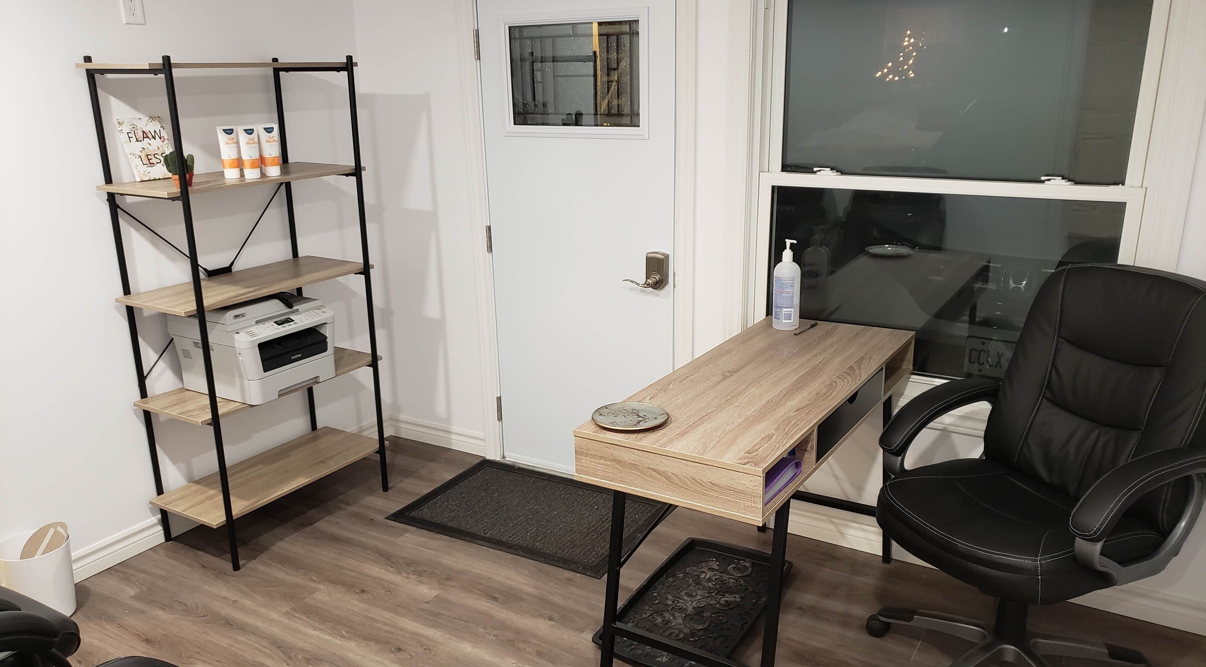Modern office space at The Sugary, Peterborough, Ontario, CA with desk, chair, and shelving unit.