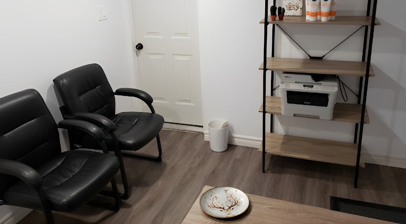 Welcoming seating area at The Sugary, Peterborough, Ontario, CA featuring leather chairs and a wooden shelf.