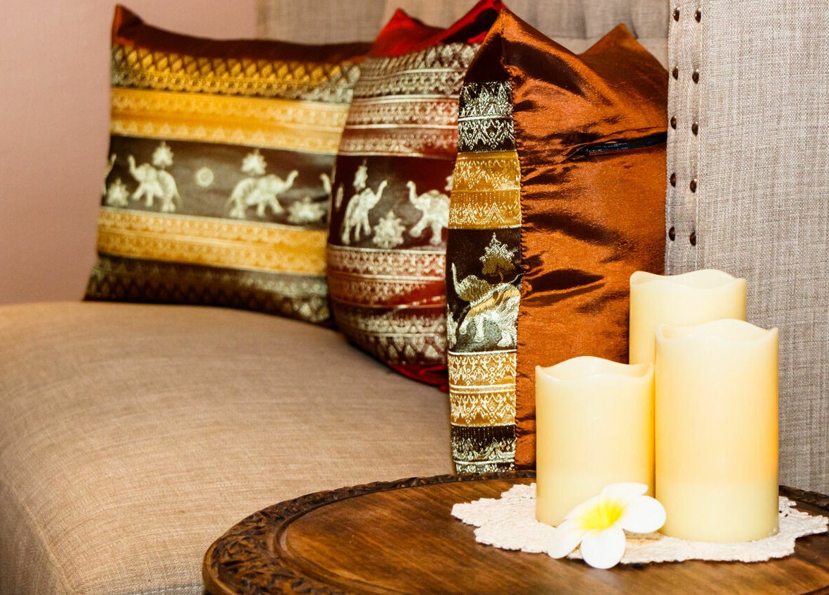 Elegant plush cushions and candles create a serene ambiance at Thai Villa Spa, Newton, Massachusetts, US.