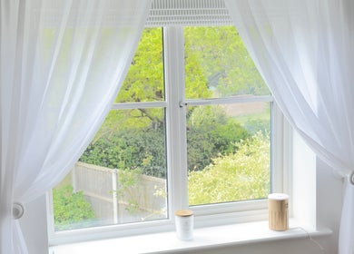 Sunny window view with flowing white curtains at The Norfolk Beauty Rooms, North Walsham, England, GB.