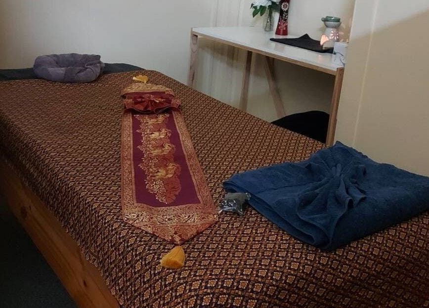 Tranquil massage room at Lotus Thai Massage Warwick, QLD, showcasing a beautifully adorned massage table.