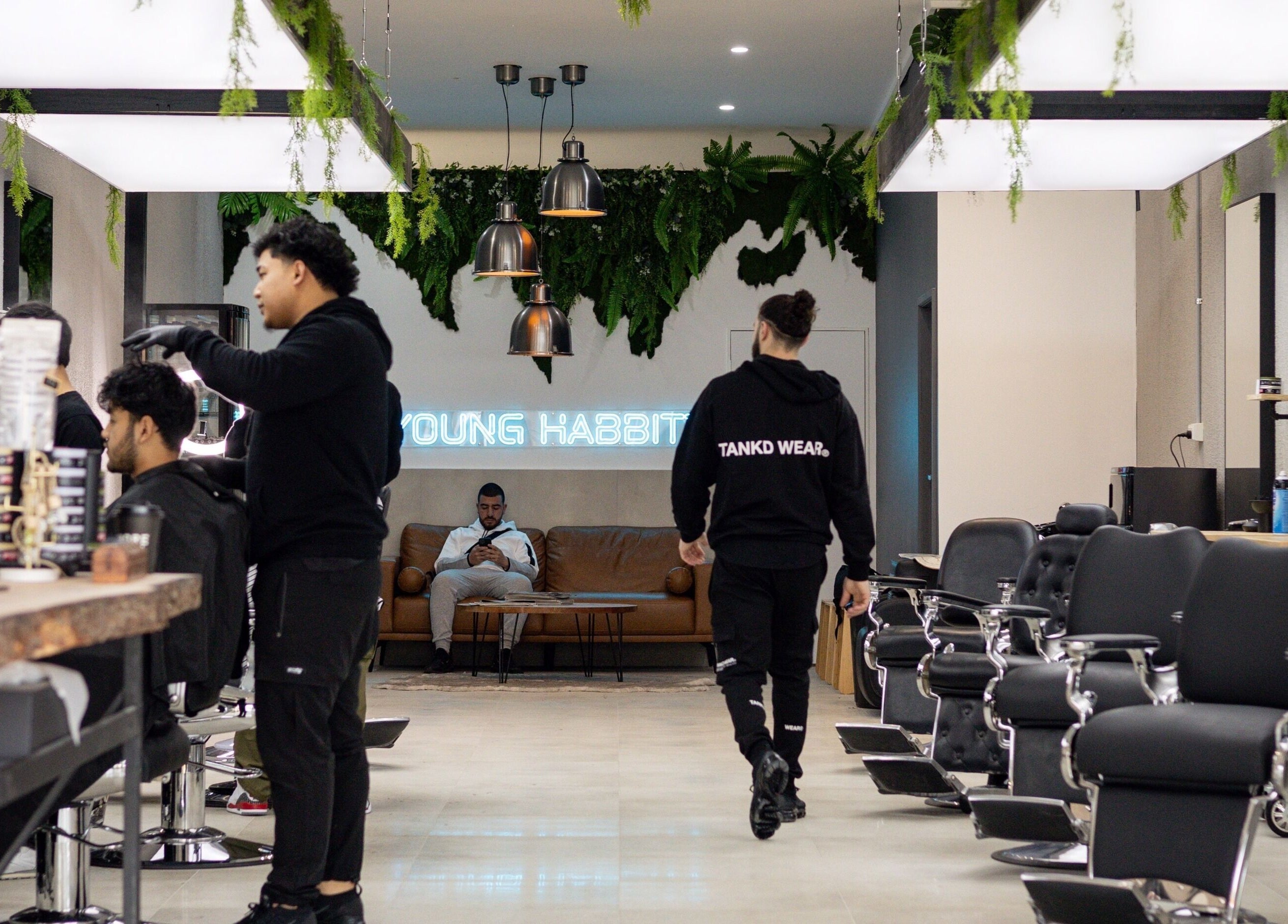Modern interior of Young Habbitt Barbers - Werribee in Melbourne, Victoria, AU with barbers and clients.