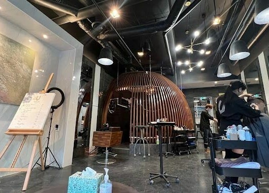 Modern interior of Vsalon in Vancouver, British Columbia, CA, showcasing unique chair design and hairstylist at work.