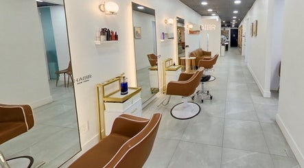 Modern salon interior at HAIIER SALON - Freelance in New York, New York, US with chic brown chairs.