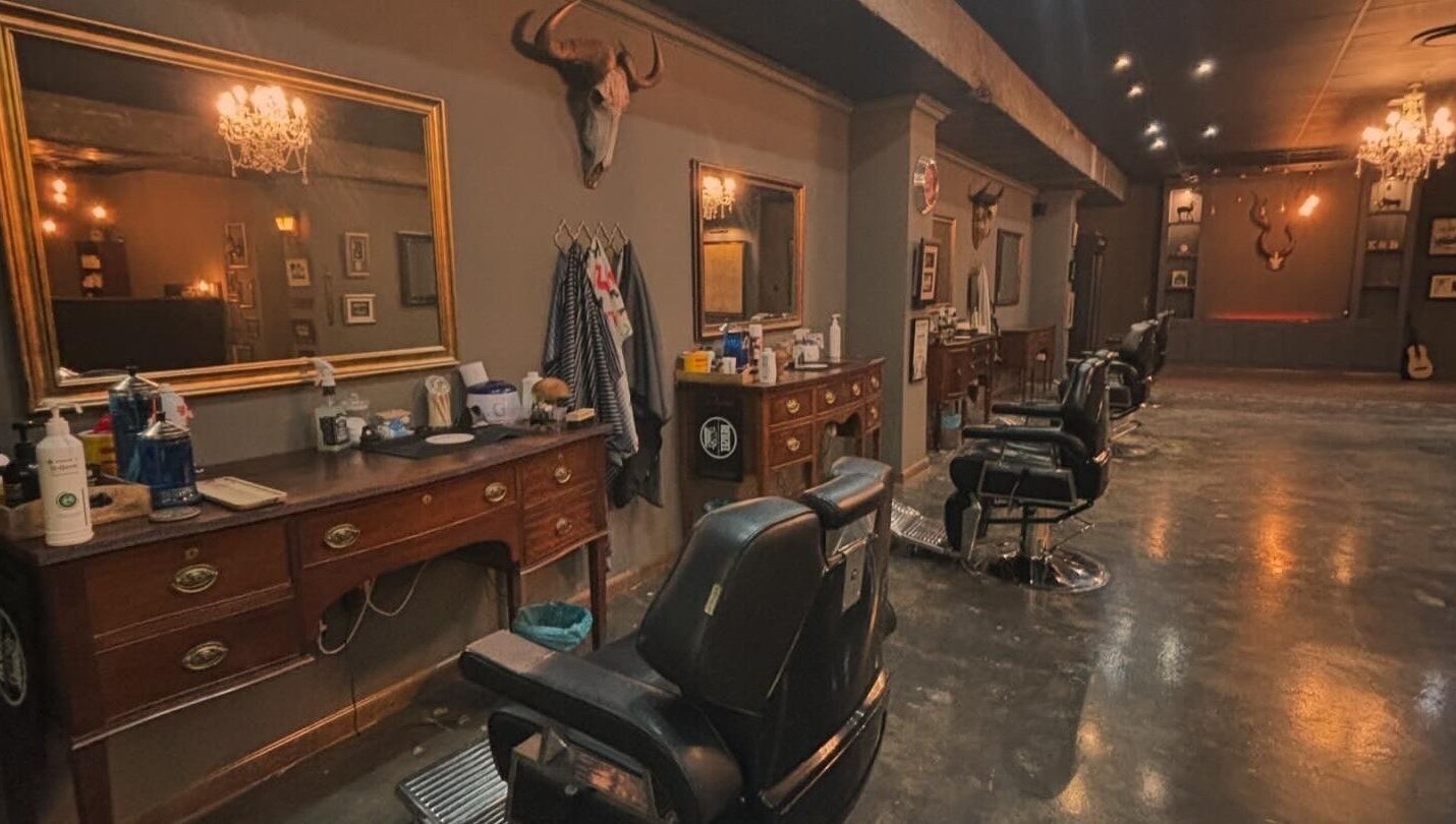 Interior view of Kuif & Baard Barbershop, Pretoria, Gauteng, ZA, featuring vintage mirrors and barber chairs.