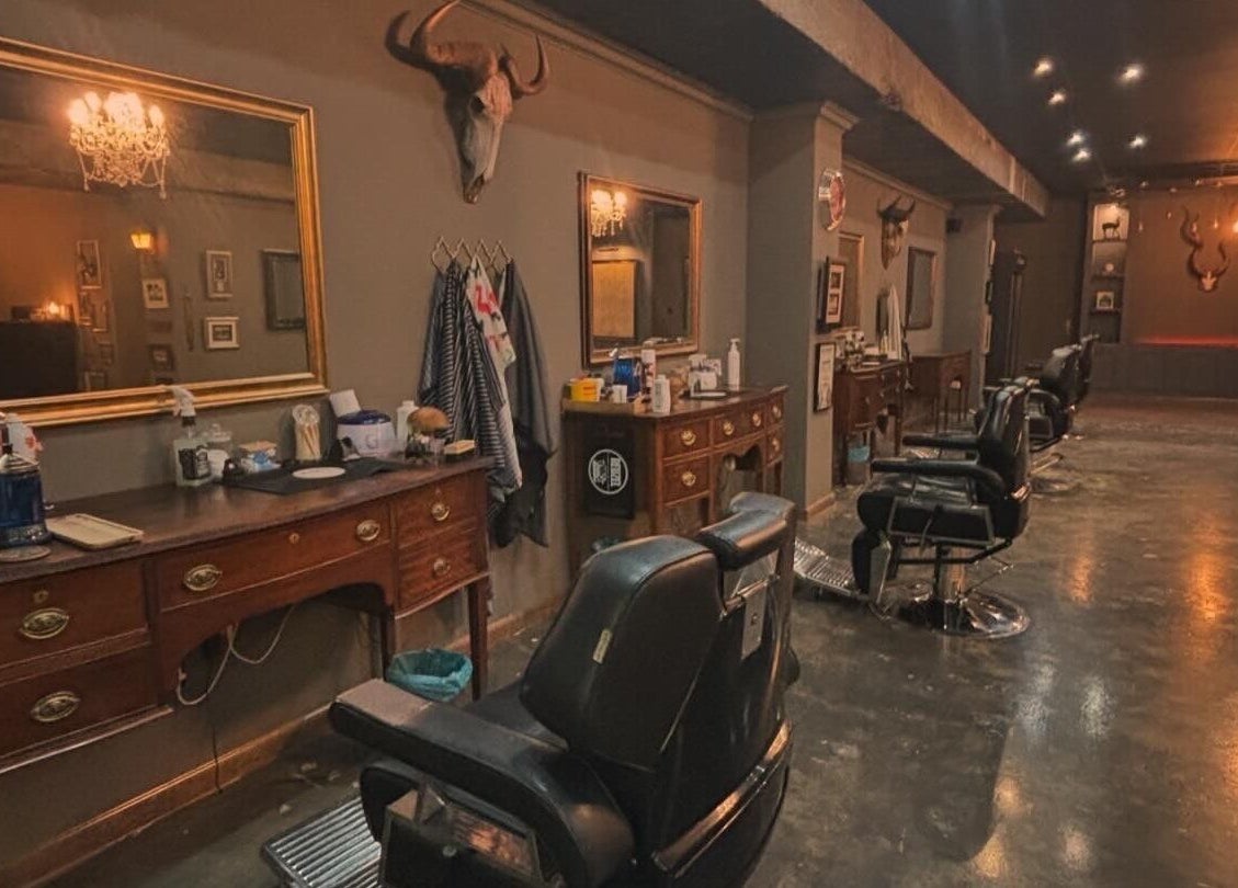 Interior view of Kuif & Baard Barbershop, Pretoria, Gauteng, ZA, featuring vintage mirrors and barber chairs.