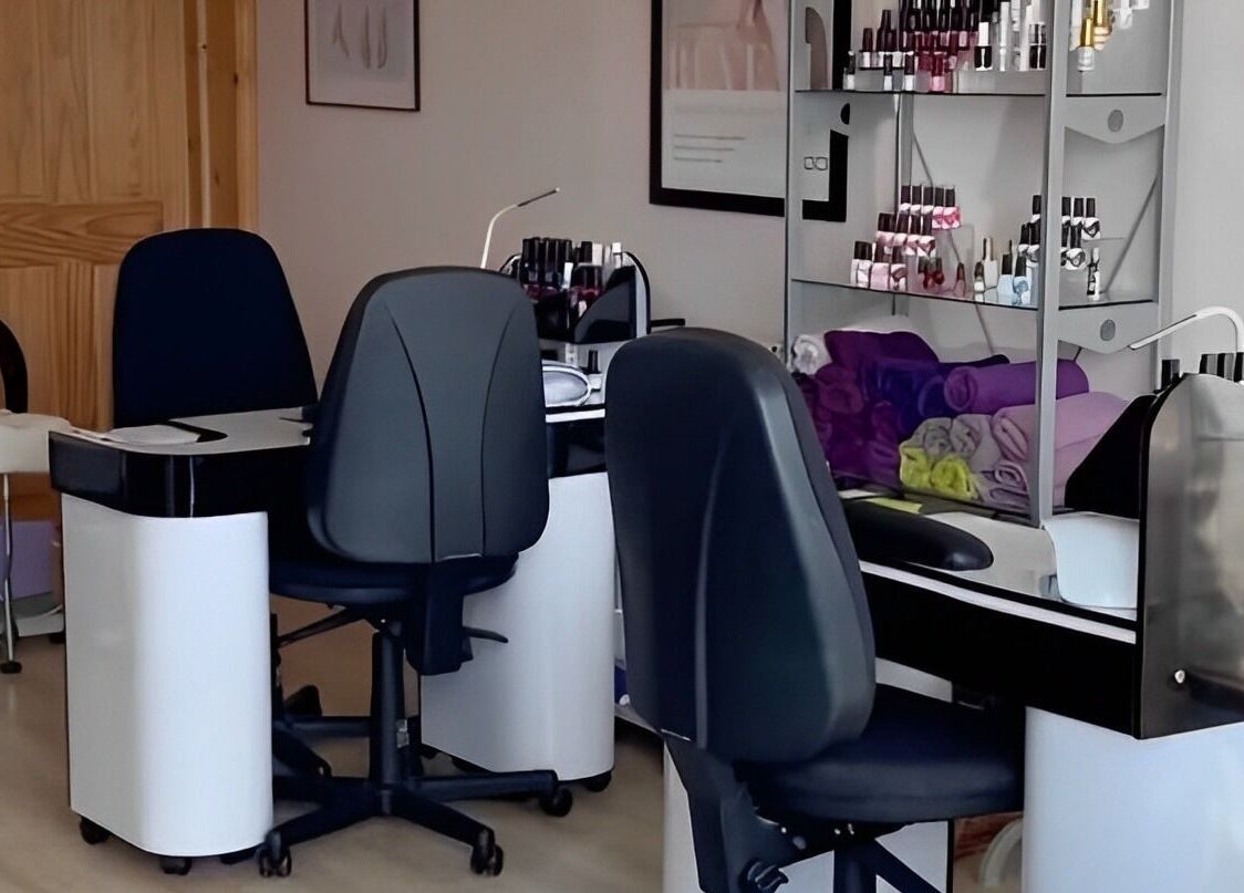 Nail care station at Barnham Health and Beauty in Barnham, England, GB, showing chairs and polish display.