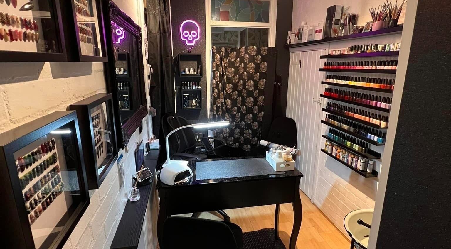 Cozy nail salon interior at Got Nails, Harlow, England, GB with colorful polish display and sleek manicure station.