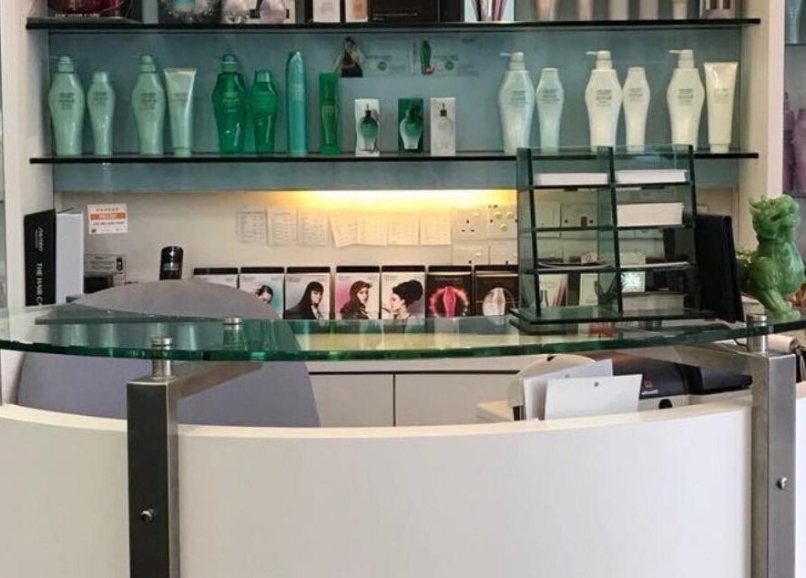 Sleek reception desk at Fortune Hair Studio, Bayan Lepas, Pulau Pinang, MY, surrounded by product shelves.