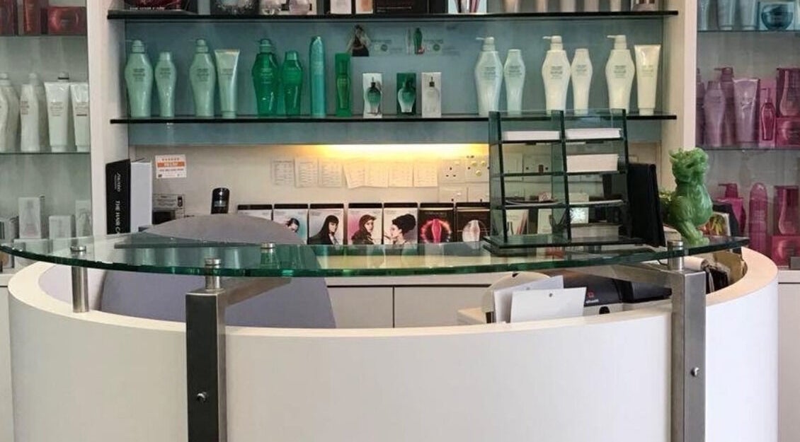 Sleek reception desk at Fortune Hair Studio, Bayan Lepas, Pulau Pinang, MY, surrounded by product shelves.