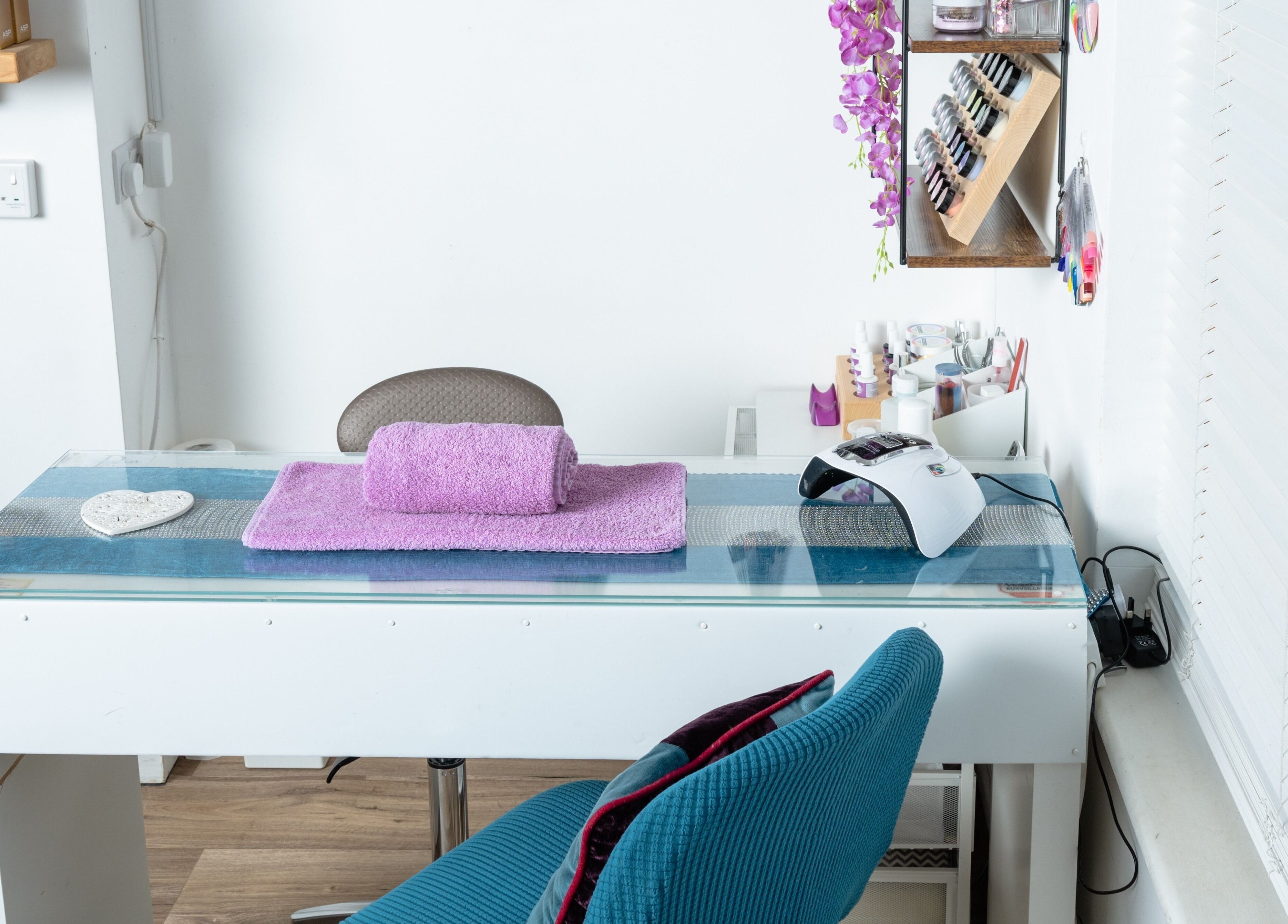 Bright, modern nail station at Pin and Pose Salon, Plymouth, England, GB. Purple towel and tools displayed.