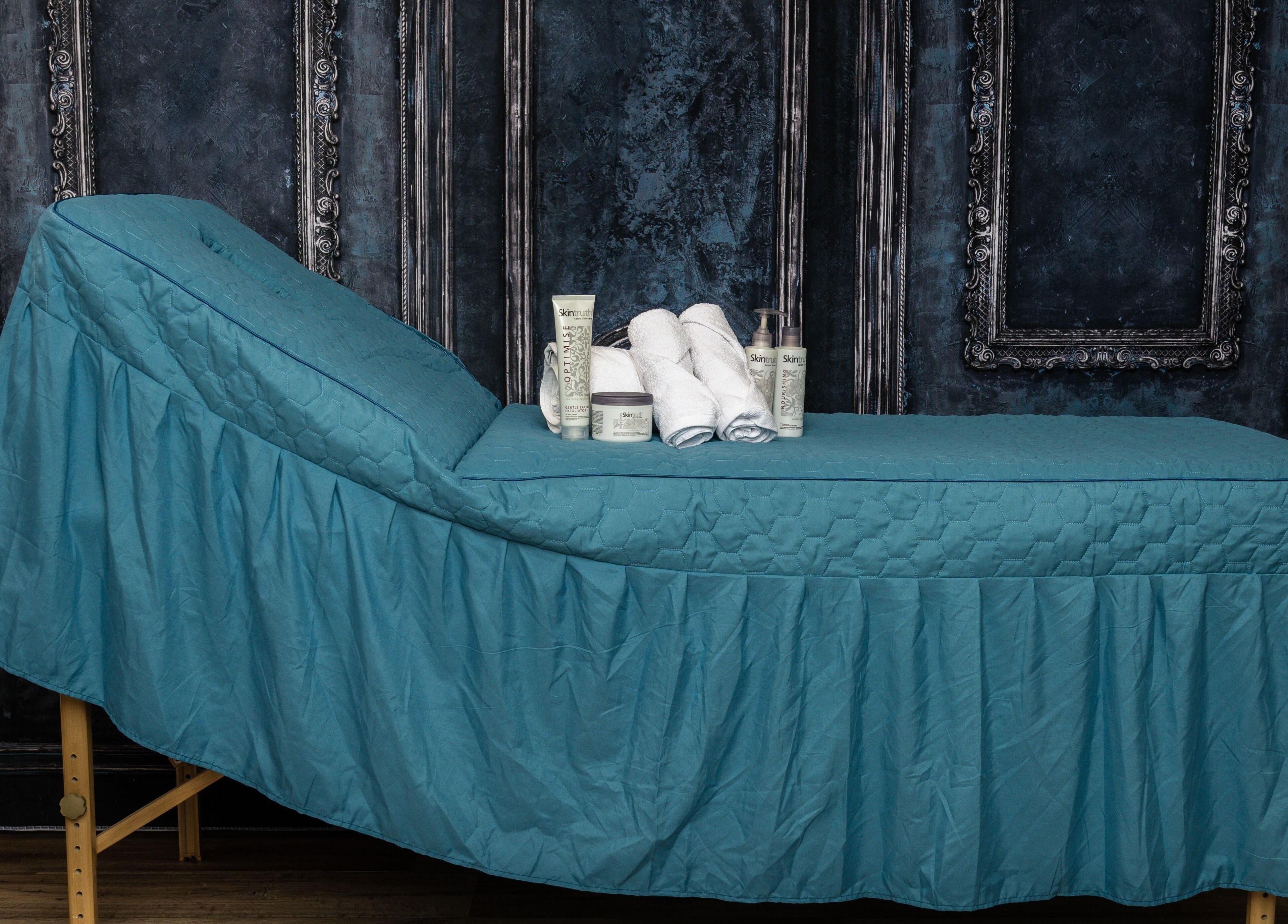 Relaxing spa table at Pin and Pose Salon, Plymouth, England, GB, with skincare products and towels.