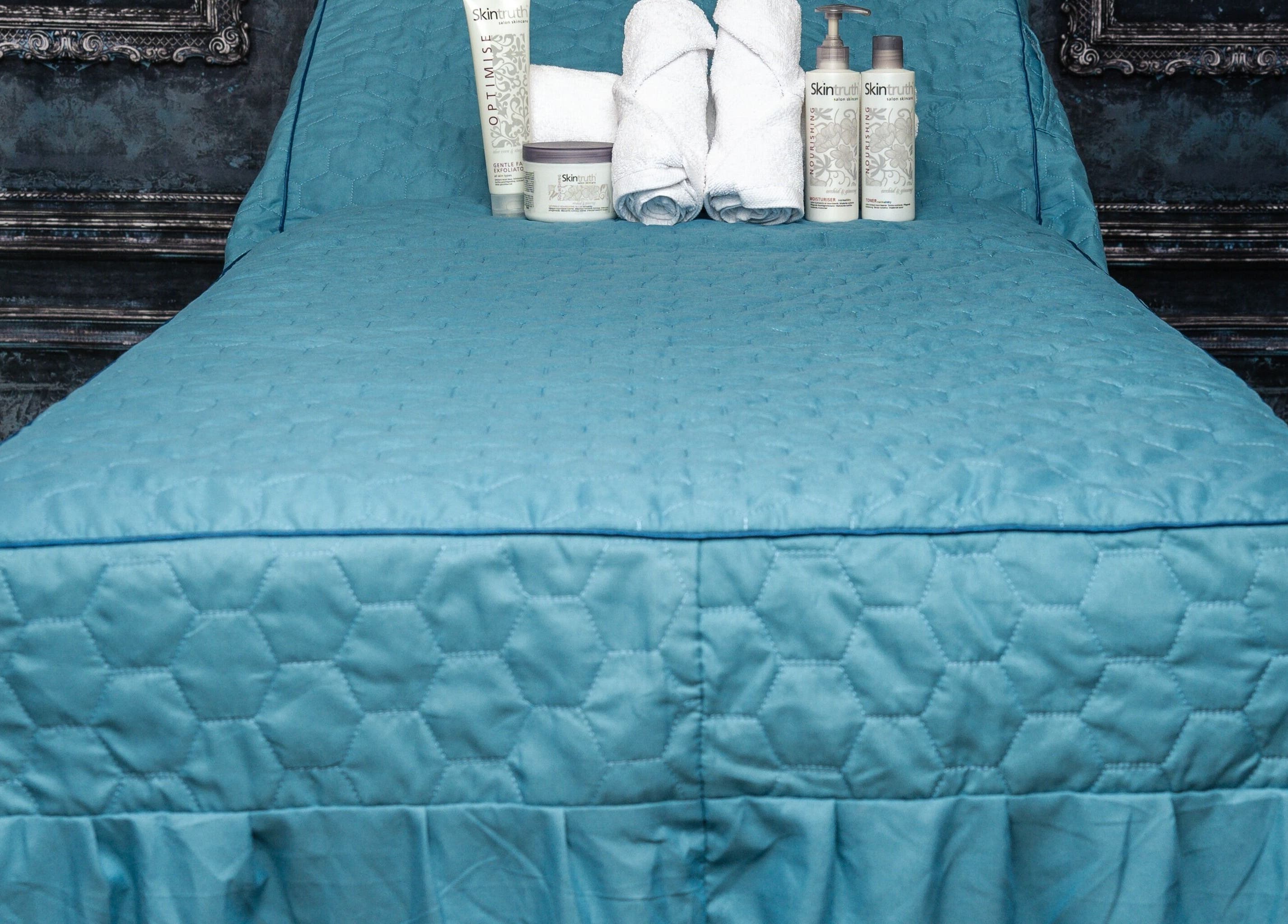 Luxurious treatment bed with skincare products at Pin and Pose Salon, Plymouth, England, GB.
