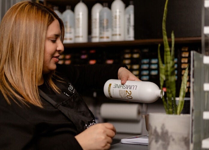 Professional hair stylist at Intrinsic Hair & Beauty in Cape Town, Western Cape, ZA preparing hair treatment.