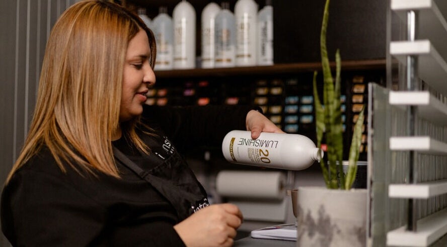 Professional hair stylist at Intrinsic Hair & Beauty in Cape Town, Western Cape, ZA preparing hair treatment.