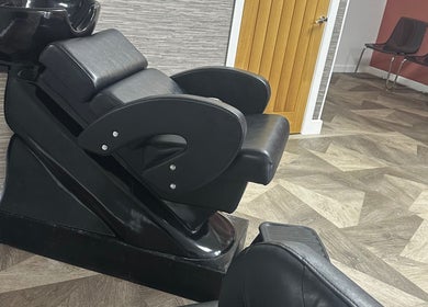 Modern hair wash station at MKT Hair & Beauty in Weymouth, England, GB, featuring sleek black seating.