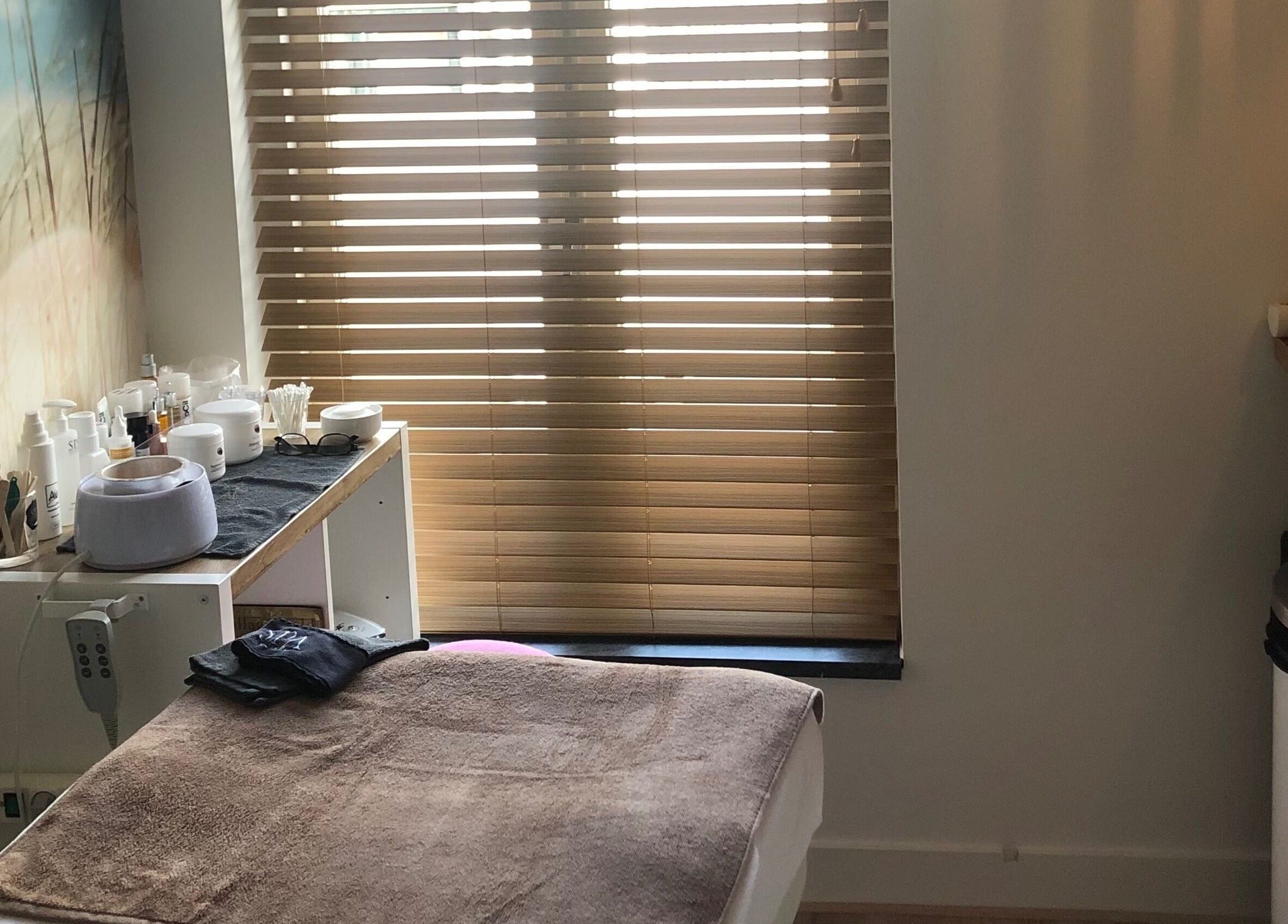 Binnenkant van Schoonheidssalon Claudia in Zandvoort, Noord-holland, NL, met wellnessproducten en behandelbed.